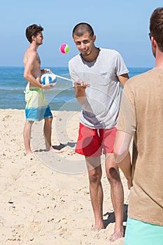 Friends playing beach football summer concept