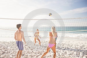 Friends playing beach volleyball