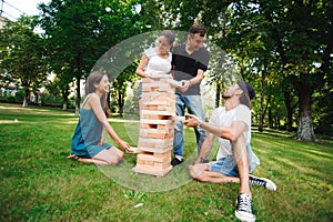 Friends playing board game. Giant Outdoor Block Game. Group game of physical skill with big blocks.