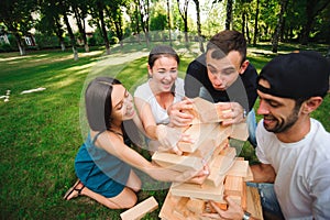 Friends playing board game outdoors. Outdoor games friends playing in a park.