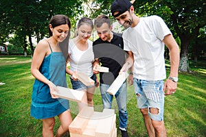 Friends playing board game outdoors in the park.