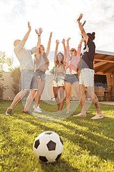 Friends playing football in backyard gathered in circle during time out