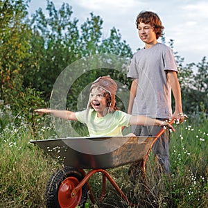 friends playing in the plane using a garden carts