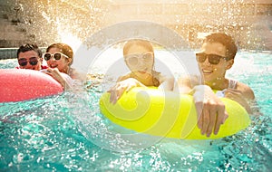 friends playing in swimming pool on summer vacation