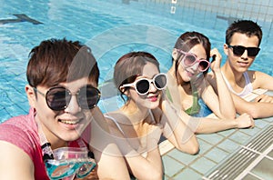 friends playing in swimming pool on summer vacation