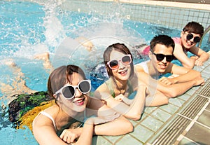 friends playing in swimming pool on summer vacation