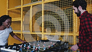 Friends playing table soccer board game indoors