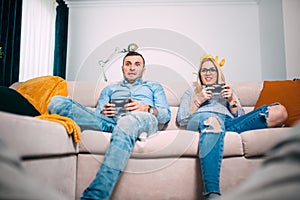 Friends playing video games with joystick Controllers. Young people having fun with modern technology and playing on console