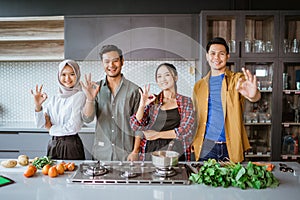 friends preparing to cook in the kitchen together showing thumb up