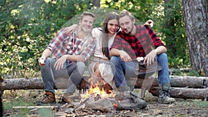 Friends relaxing near campfire after day hiking or gathering mushrooms. Tourism concept. Best friends spend leisure