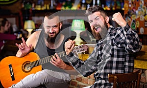 Friends relaxing in pub. Live music concert. Man play guitar in pub. Acoustic performance in pub. Hipster brutal bearded