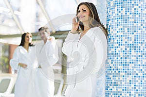 Friends relaxing in a spa next to a swimming pool