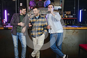 Friends resting in the pub with beer in hands. Having conversation.