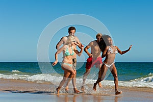 Friends running on beach vacation