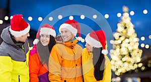 Friends in santa hats and ski suits at christmas