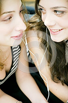 Friends sharing headphones