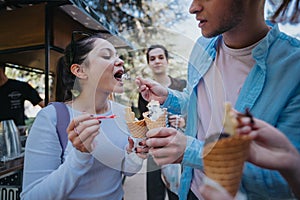 Friends sharing ice cream at a park on a sunny day, enjoying sweet treats together