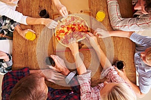 Friends sharing a pizza together, overhead view