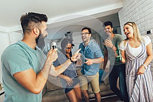 Friends singing together at home. Karaoke party concept