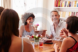 Friends sitting at a dining table laughing together