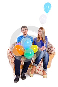 Friends sitting on a sofa with balloons isolated