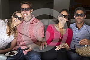 Friends Sitting On Sofa Watching TV Wearing 3-D Glasses