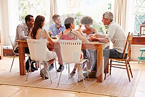 Friends sitting at a table talking during a dinner party