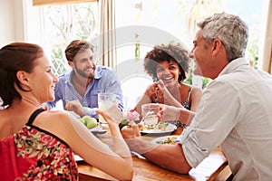 Friends sitting at a table talking during a dinner party