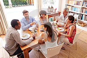 Friends sitting at a table talking during a dinner party