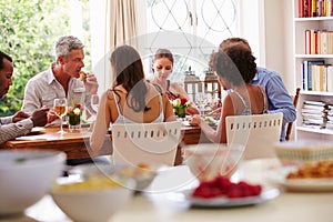 Friends sitting at a table talking during a dinner party