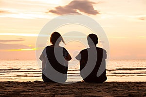 Friends sitting together on the beach