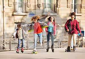 Friends skateboarding and rollerblading in city