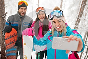 Friends snowboarders or skiers making selfie in fog forest