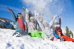 Friends with snowboards throwing snow