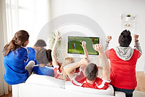 Friends or soccer fans watching game on tv at home