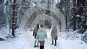 Friends spend weekend time walking along winter forest