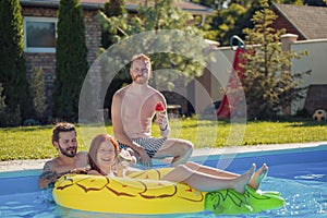 Friends spending hot summer day at the swimming pool