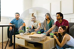 Friends sport fans enjoying a football game on tv