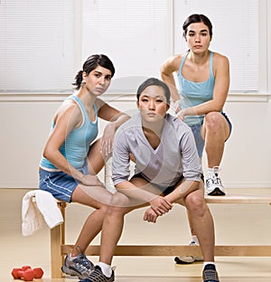 Friends in sportswear sitting on bench