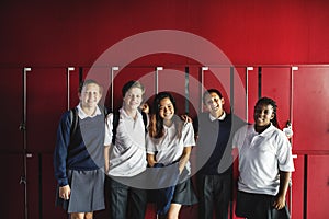 Friends standing together in front of lockers