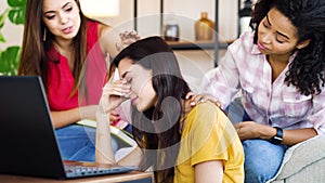 Friends supporting sad girl receiving bad news on laptop at home