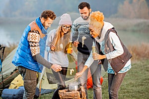 Friends in sweaters eating fondue outdoors