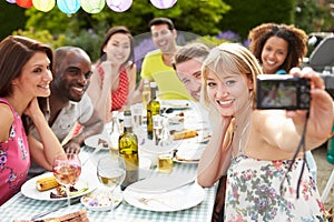 Friends Taking Self Portrait On Camera At Outdoor Barbeque