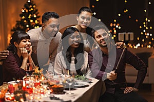 friends taking selfie on christmas dinner at home