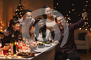 friends taking selfie on christmas dinner at home