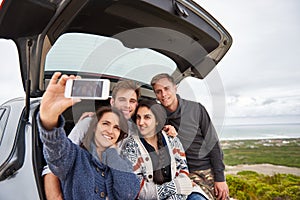 Friends taking selfie while on a roadtrip along the coast