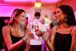Friends, toast and new year party at disco, event and nightclub with happy smile, celebration and nightlife. Women