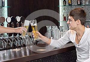 Friends toasting as they enjoy a pint of beer