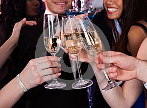 Friends toasting champagne at nightclub