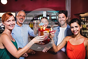 Friends toasting drink glasses in nightclub